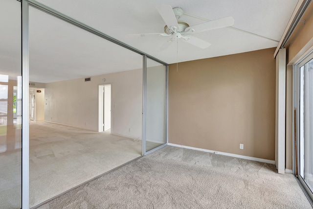 unfurnished bedroom with ceiling fan, light carpet, and a closet