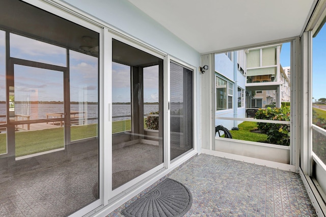 unfurnished sunroom featuring a water view