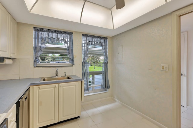 kitchen featuring stainless steel dishwasher, light tile patterned floors, sink, and tasteful backsplash