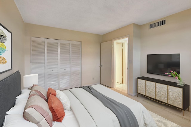 carpeted bedroom featuring a textured ceiling and a closet