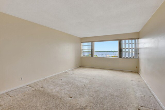 60 Yacht Club Dr Unit 106, North Palm Beach, FL 33408 - unfurnished room featuring carpet, a water view, and baseboards