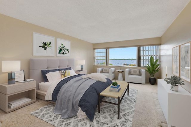 bedroom featuring a textured ceiling, light carpet, and a water view