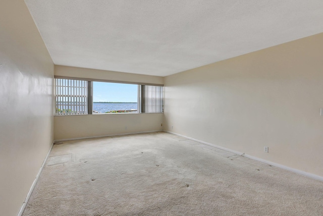 60 Yacht Club Dr Unit 106, North Palm Beach, FL 33408 - empty room featuring carpet floors, baseboards, and a water view