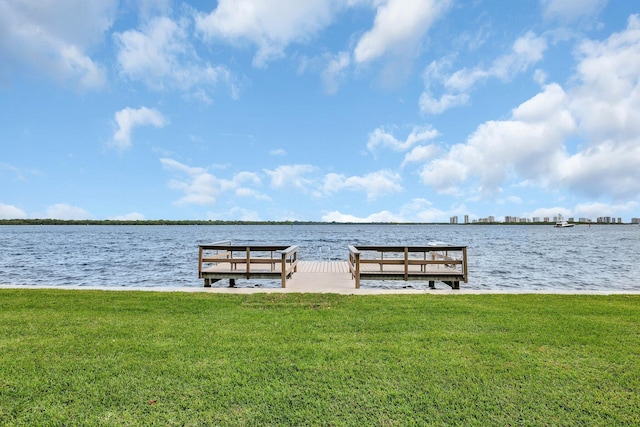 dock area with a water view and a lawn