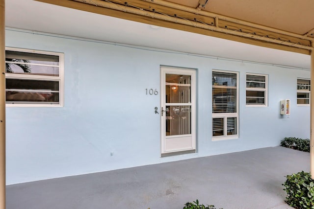 60 Yacht Club Dr Unit 106, North Palm Beach, FL 33408 - view of exterior entry with stucco siding and a patio area