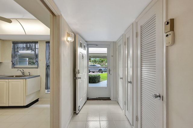 doorway to outside with sink and light tile patterned floors