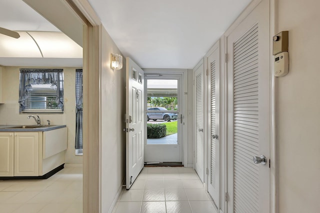 60 Yacht Club Dr Unit 106, North Palm Beach, FL 33408 - hallway featuring a sink, light tile patterned floors, and baseboards