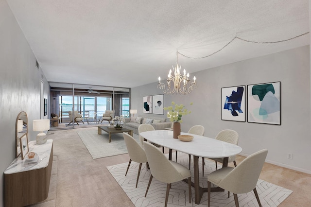 dining room featuring light colored carpet, a notable chandelier, and a textured ceiling