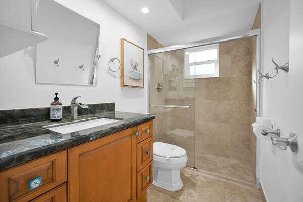 bathroom with tile patterned flooring, vanity, a shower with shower door, and toilet