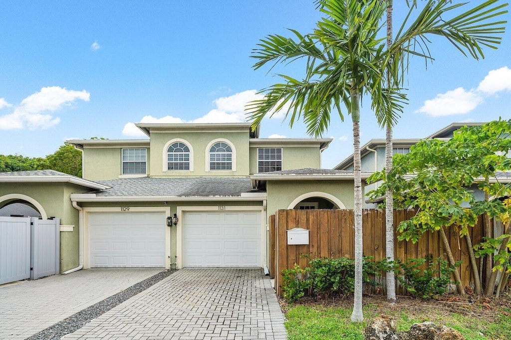1131 NE 3rd Ave, Fort Lauderdale, FL 33304 - view of front of property with stucco siding, driveway, fence, a garage, and a gate