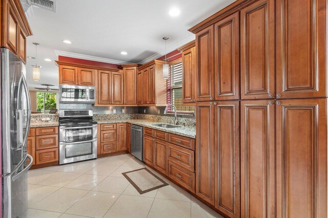 kitchen featuring stainless steel appliances, sink, light tile patterned floors, decorative light fixtures, and crown molding