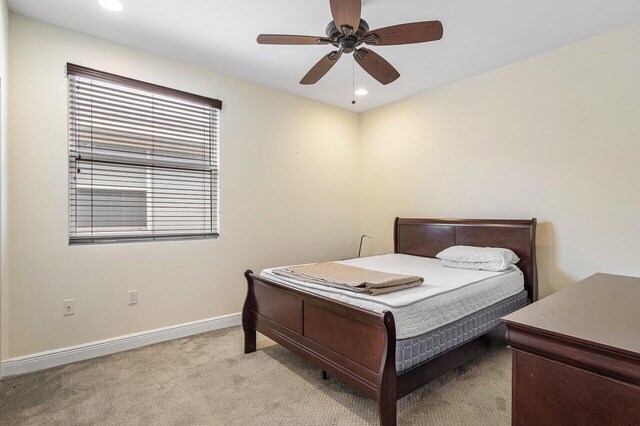 bedroom with light carpet and ceiling fan