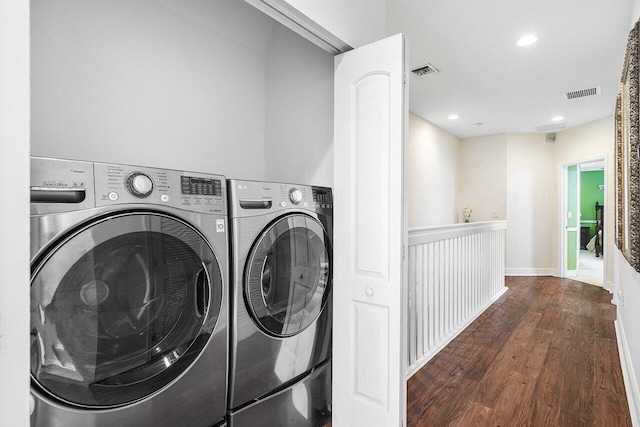 laundry room with dark wood-type flooring and separate washer and dryer