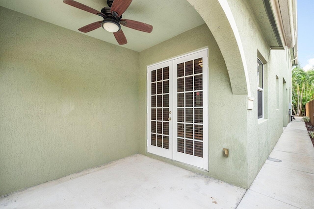 entrance to property with ceiling fan, a patio, and french doors