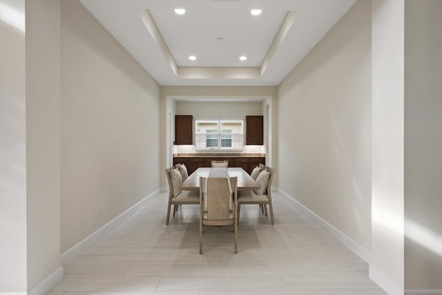 dining space featuring a raised ceiling