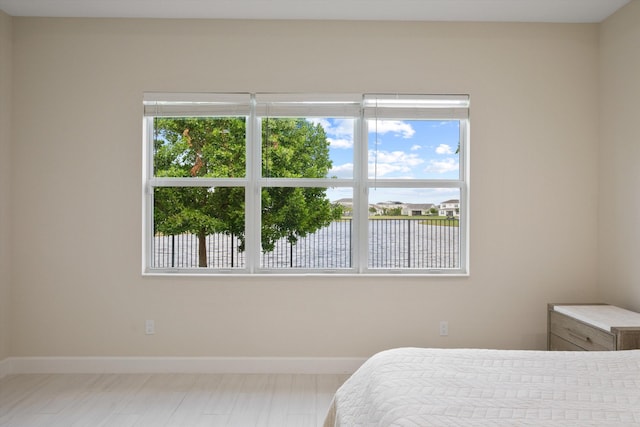 bedroom with multiple windows and a water view