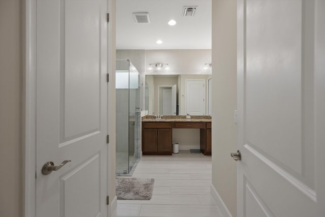 bathroom with an enclosed shower and vanity