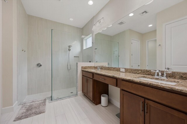 bathroom with vanity and tiled shower