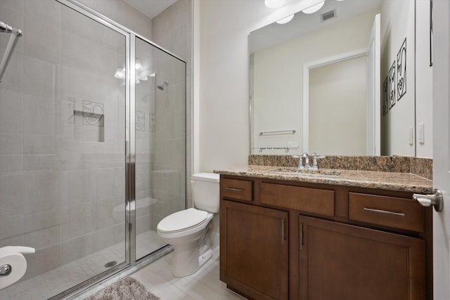 bathroom featuring vanity, a shower with shower door, and toilet