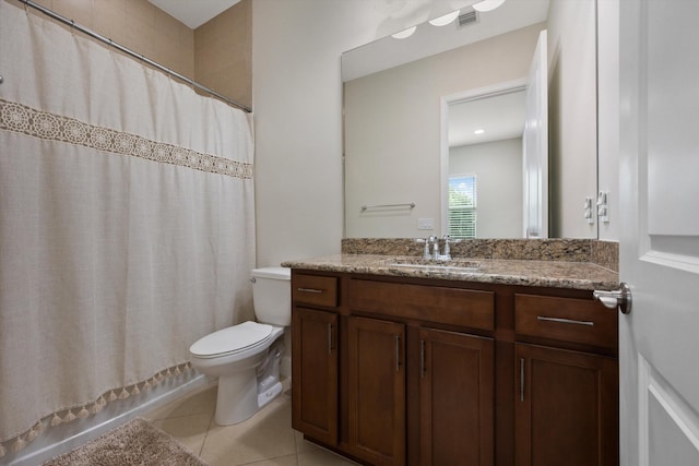 bathroom featuring tile patterned flooring, vanity, toilet, and walk in shower