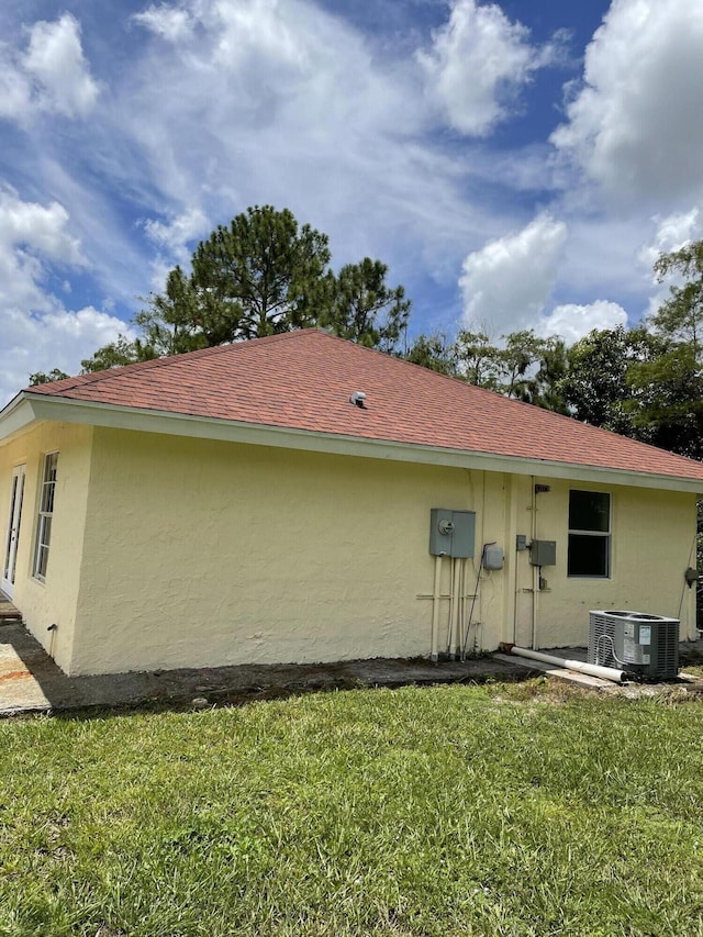 rear view of house with a yard and central air condition unit