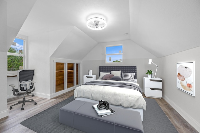 bedroom featuring hardwood / wood-style flooring and lofted ceiling