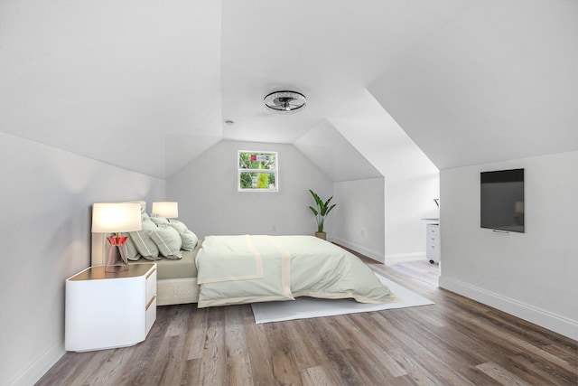 unfurnished bedroom featuring hardwood / wood-style floors and lofted ceiling