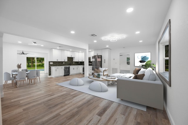 living room with ceiling fan and light hardwood / wood-style flooring