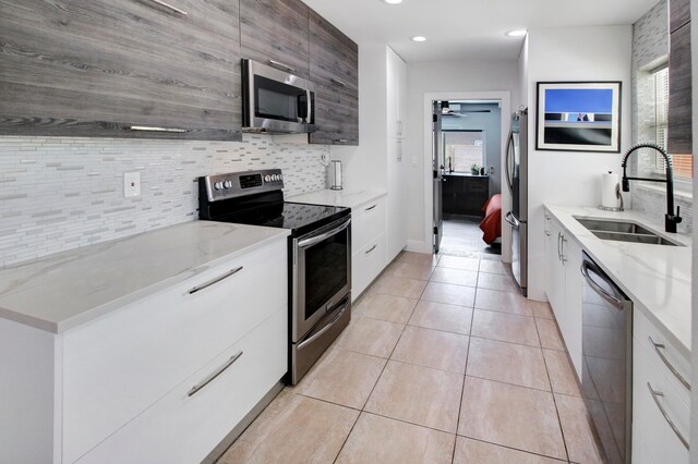 kitchen with plenty of natural light, white cabinets, sink, and stainless steel appliances