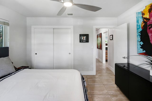 tiled bedroom featuring ceiling fan and a closet