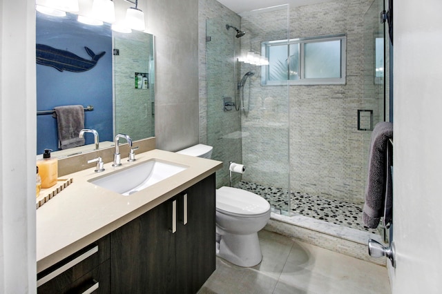 bathroom featuring vanity, tile patterned floors, toilet, and a shower with shower door