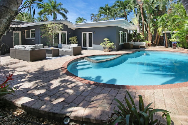 view of swimming pool featuring an outdoor living space, a patio, french doors, and an in ground hot tub