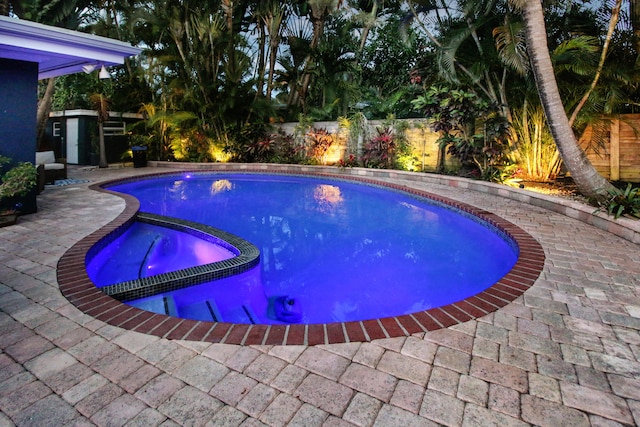 view of pool with a patio area and an in ground hot tub