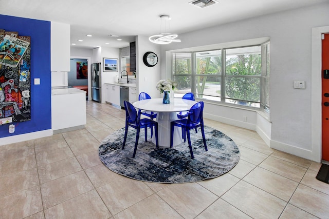 tiled dining room featuring a chandelier and sink