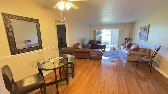 living room with baseboards, ceiling fan, and wood finished floors