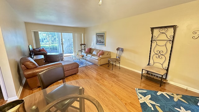 living area with baseboards and wood finished floors