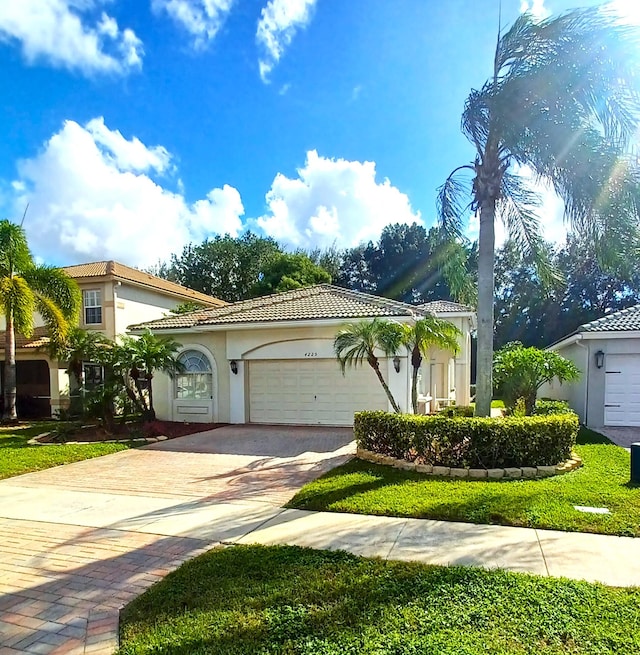 mediterranean / spanish home featuring a front yard and a garage