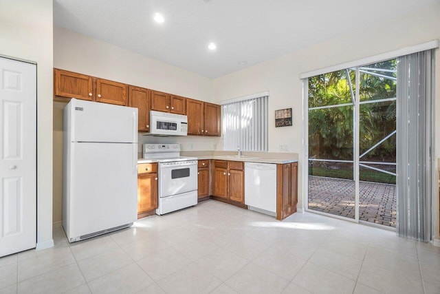 kitchen with sink, light tile patterned flooring, and white appliances