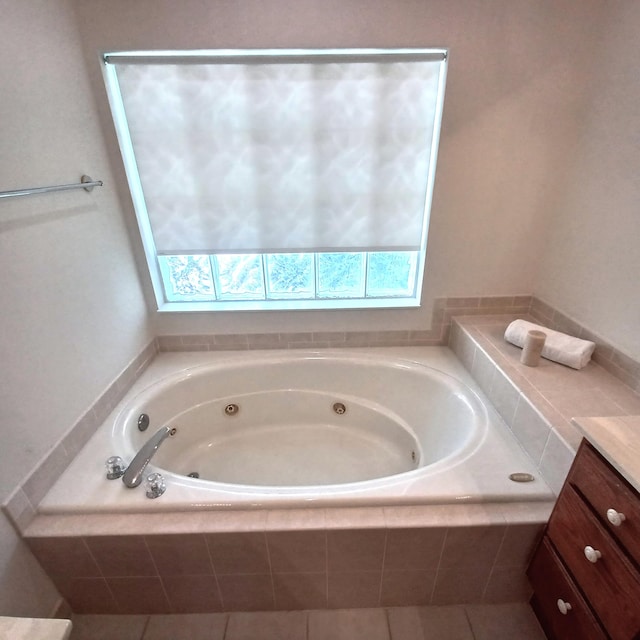 bathroom featuring vanity and tiled tub