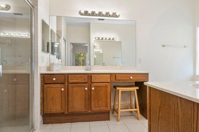 bathroom with tile patterned flooring, vanity, and an enclosed shower