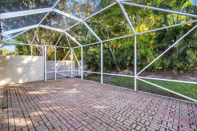 view of patio featuring glass enclosure