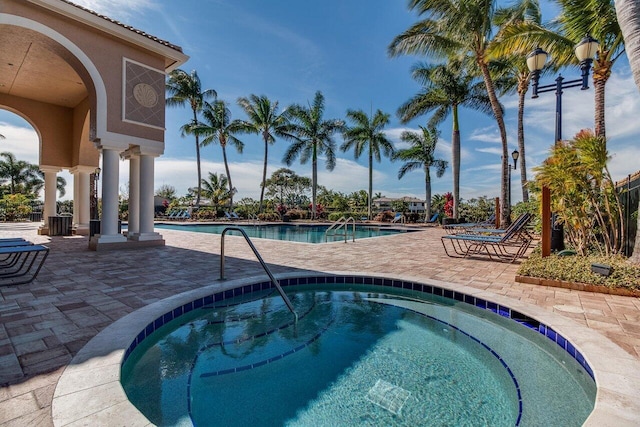 view of pool with a patio and a hot tub