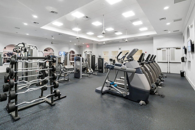 workout area featuring a paneled ceiling, crown molding, and a tray ceiling