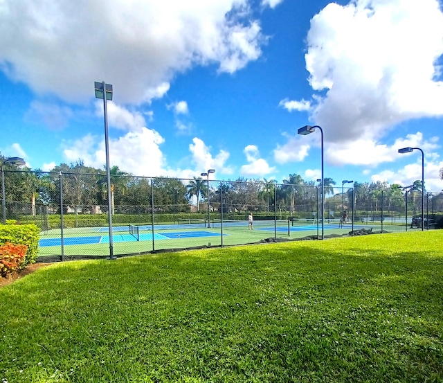 view of tennis court featuring a lawn