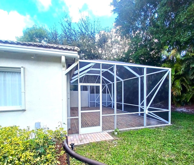 exterior space with a lawn and glass enclosure