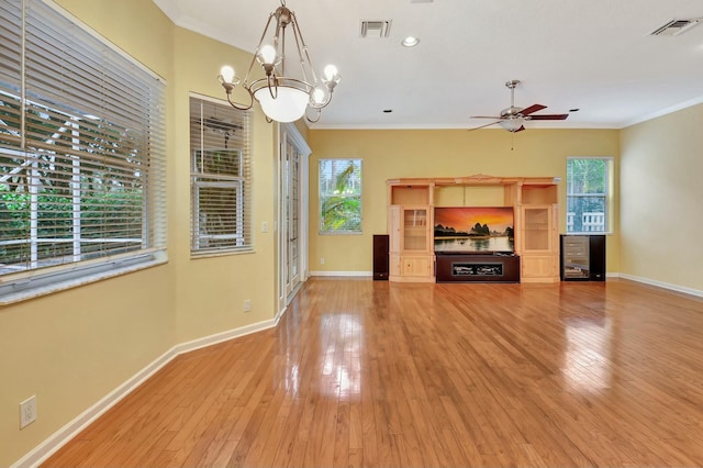 unfurnished living room featuring ceiling fan with notable chandelier, crown molding, and light hardwood / wood-style flooring