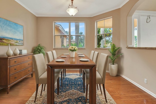 dining space with light hardwood / wood-style flooring and ornamental molding