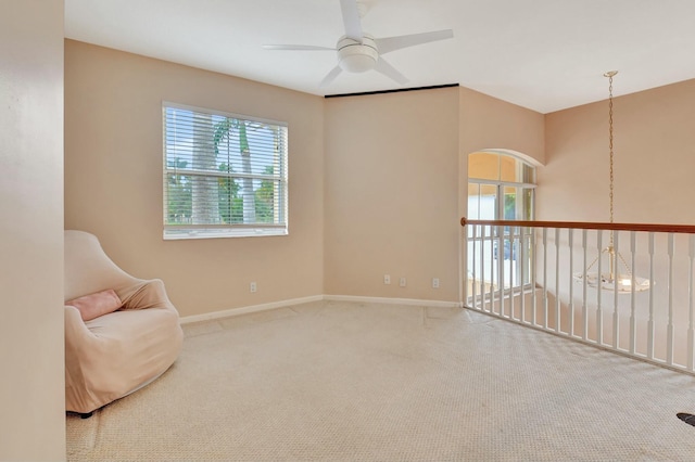 living area with carpet and ceiling fan