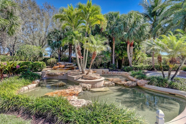 view of property's community with a garden pond