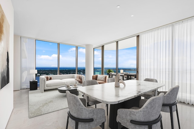 dining area featuring expansive windows and a water view